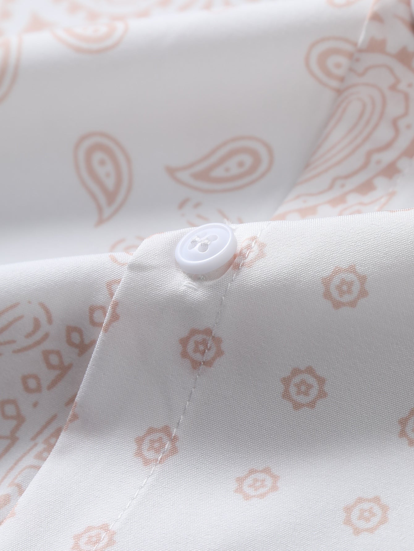 Camisa abotonada con estampado paisley y bañador corto.