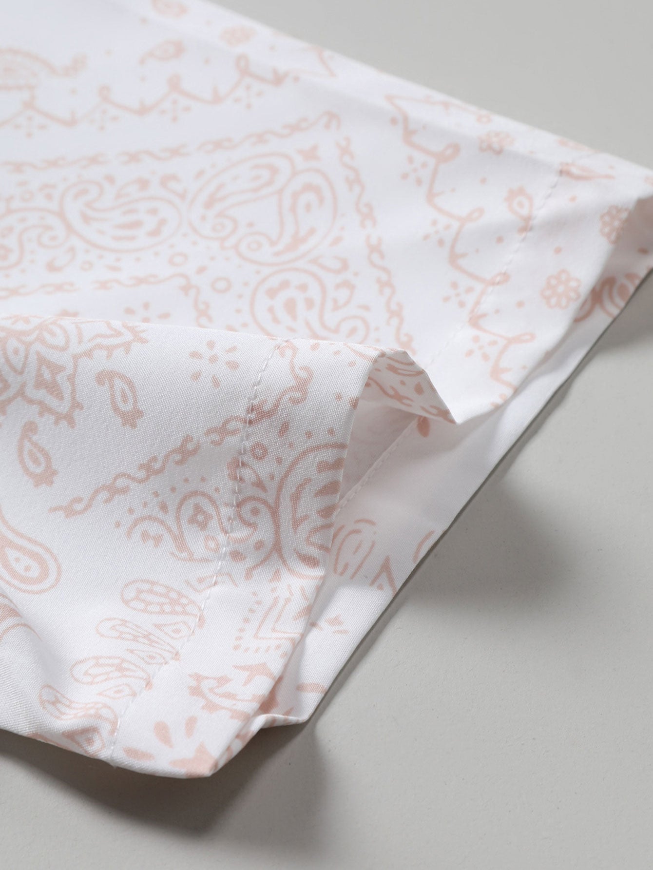 Camisa abotonada con estampado paisley y bañador corto.