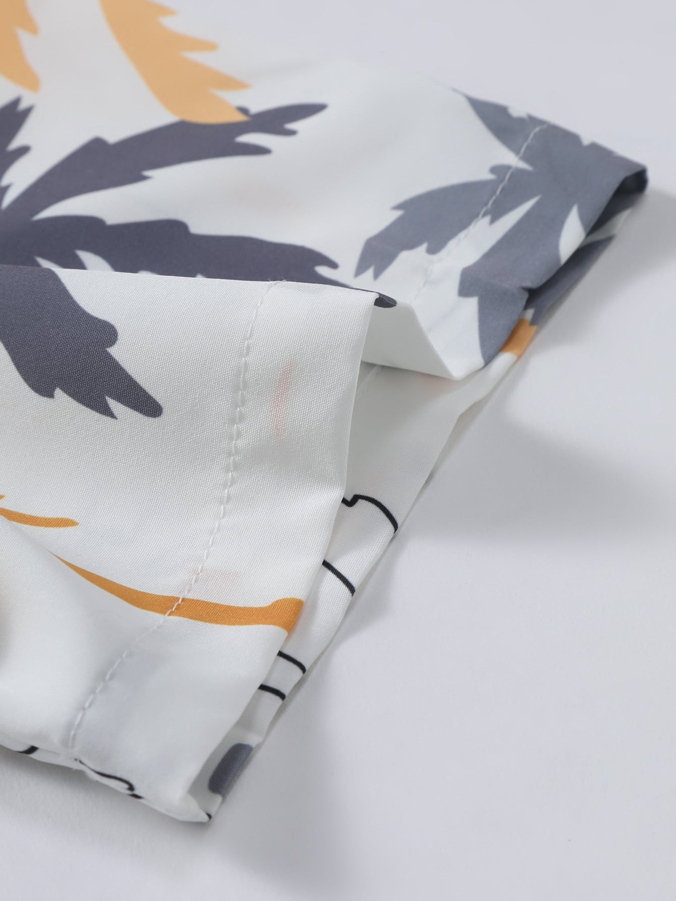 Camisa abotonada con estampado de palmeras y bañador corto.