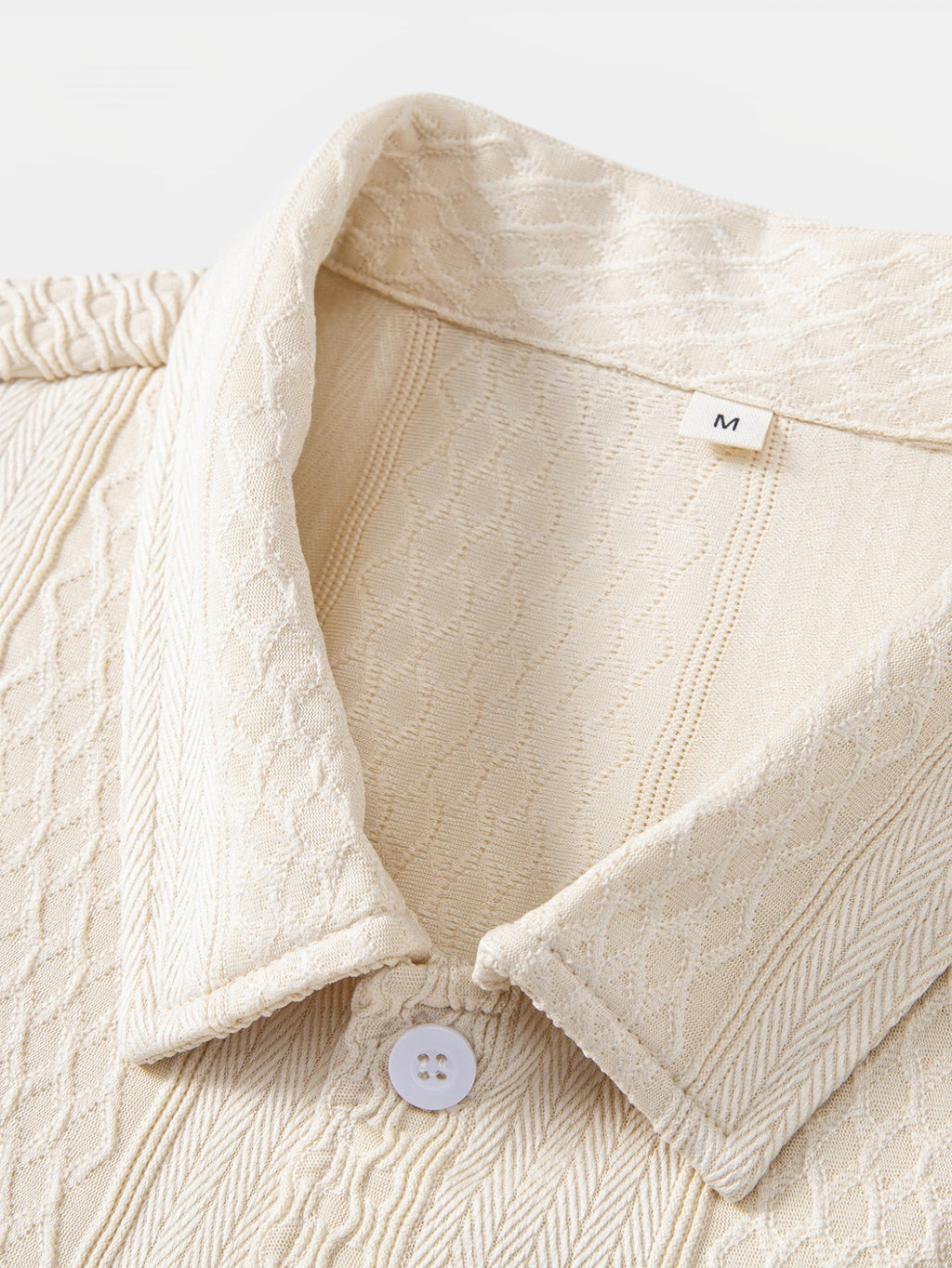 Camisa abotonada de jacquard geométrico y pantalones rectos con textura arrugada.