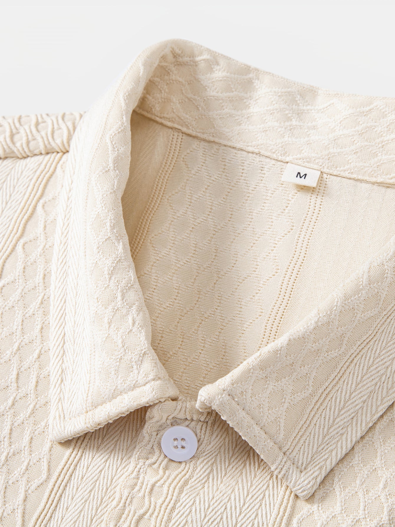 Camisa abotonada de jacquard geométrico y pantalones rectos con textura arrugada.